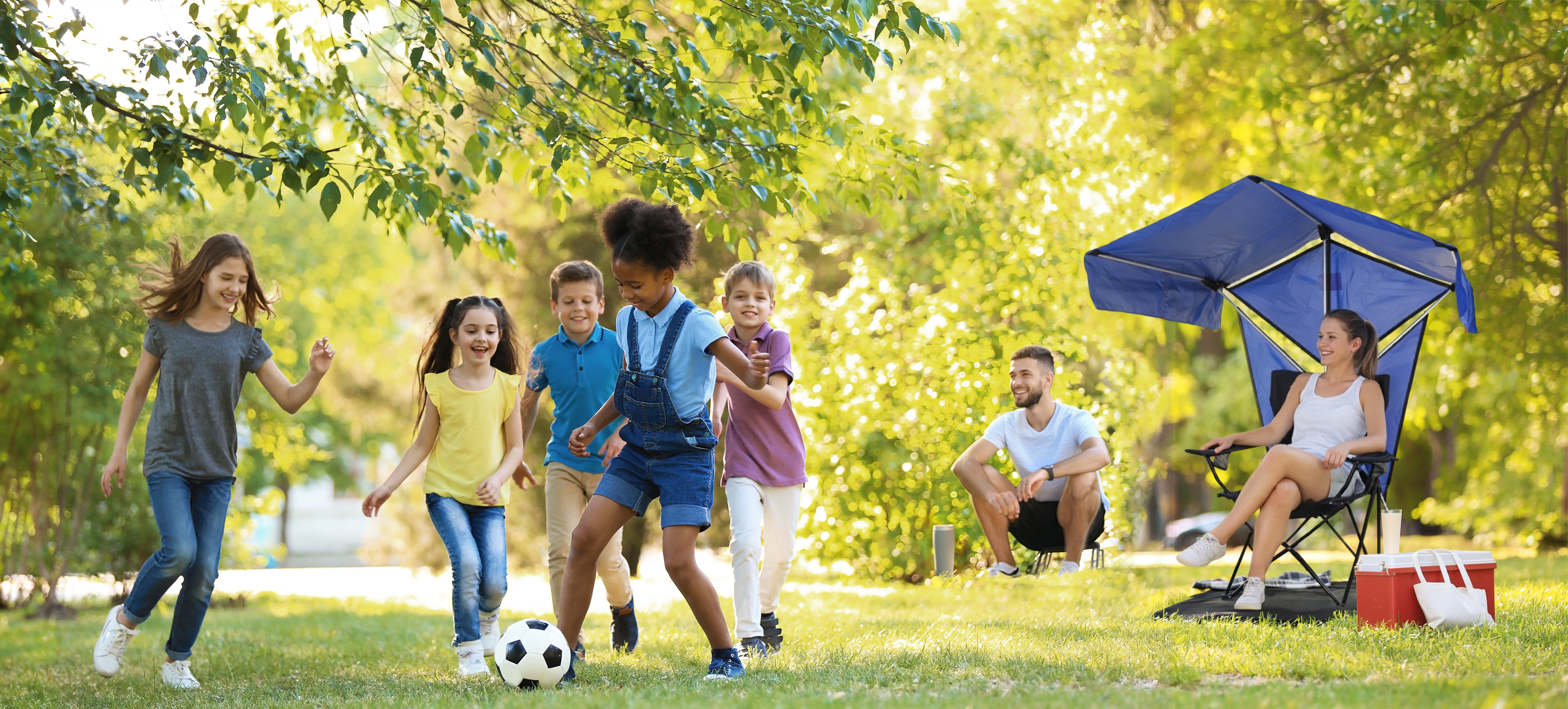 Parents watching youth soccer from the sideline under Bandanna Shade